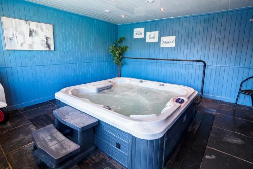una vasca idromassaggio in una camera blu di Sennen a Budock Water