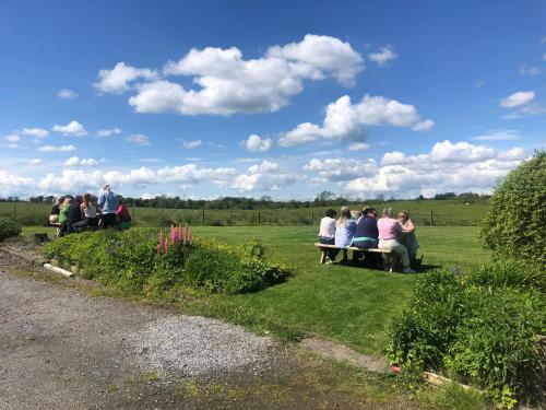 a group of people sitting on a bench in a field at The Crossings in Carlisle