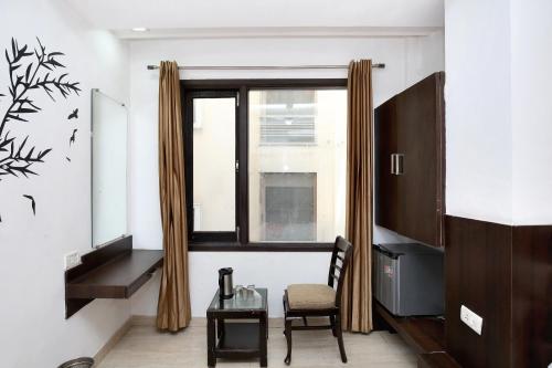 a room with a table and a chair and a window at Hotel Winner Inn in Amritsar