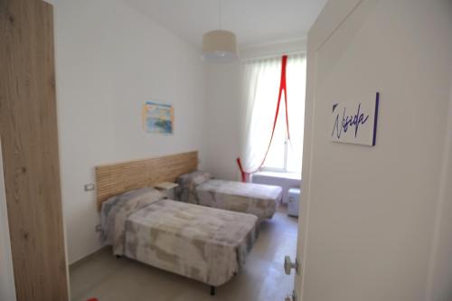 a room with two beds and a window at M'incanto B&B in Naples