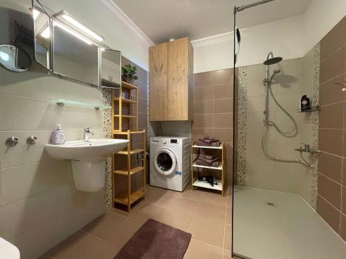 a bathroom with a sink and a washing machine at Appartement Mezzanine in Hévíz