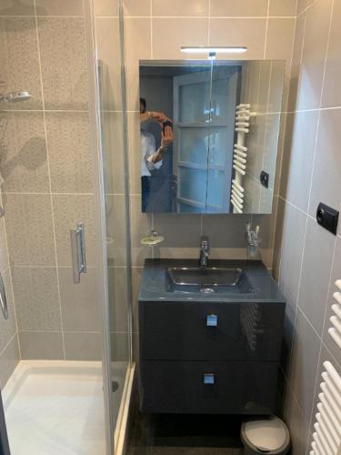 un homme prenant une photo d'une salle de bains avec douche dans l'établissement Antibes Secured Parc Velusine with private parking, Terrace, Pools and Tennis courts., à Antibes