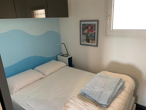 a bedroom with a white bed with a blue headboard at Antibes Secured Parc Velusine with private parking, Terrace, Pools and Tennis courts. in Antibes