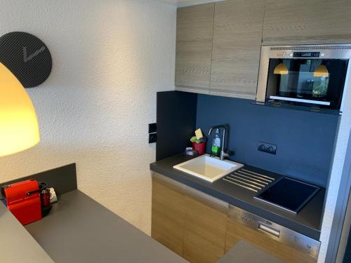 a small kitchen with a sink and a microwave at Antibes Secured Parc Velusine with private parking, Terrace, Pools and Tennis courts. in Antibes