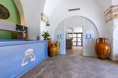 a restaurant with a blue counter and vases at Hotel Masseria Fontanelle in Ugento