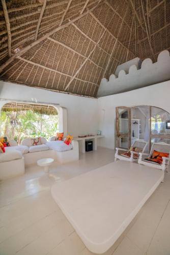 sala de estar con muebles blancos y techo en Msambweni Beach House and Private Villas, en Msambweni