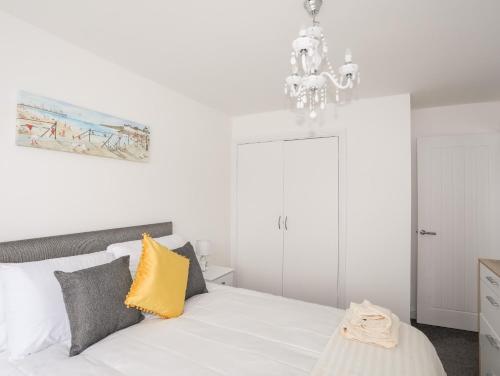 a bedroom with a white bed with a yellow pillow at Valley House in Holyhead