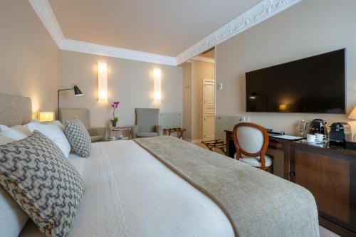 a bedroom with a large bed with a flat screen tv at Hotel Rector in Salamanca