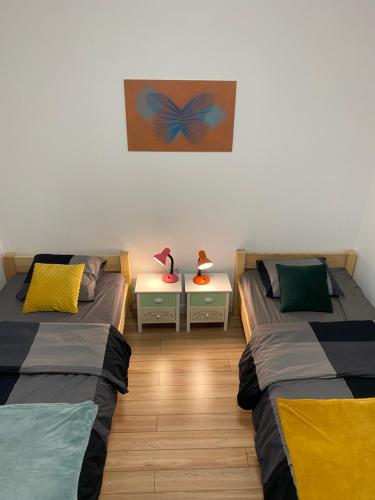 a room with two beds and a table with lamps at Żwirek Muchomorek in Sterławki Małe