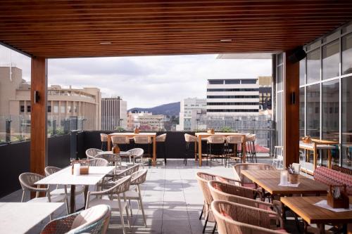 a restaurant with tables and chairs and a view of a city at Crowne Plaza Hobart by IHG in Hobart