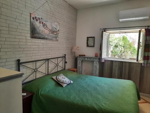sypialnia z zielonym łóżkiem i oknem w obiekcie La casa nella roccia w mieście Napoli