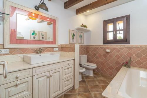 a bathroom with a sink and a toilet and a mirror at Can Pontet in Vilafranca de Bonany