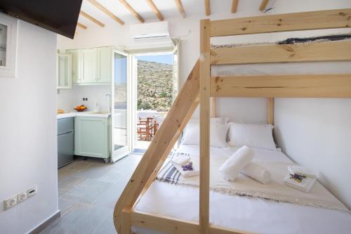 Harmony View Lux studio with stunning Sea Views في Sifnos: غرفة نوم مع سرير بطابقين ومطبخ