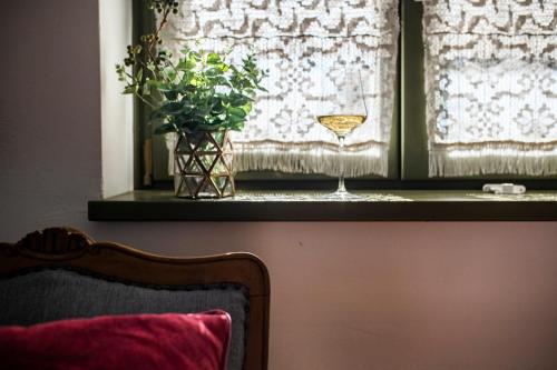 a window sill with a wine glass and a vase at NemCsuri Vendegház Somló in Somlóvásárhely