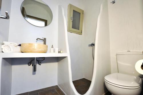 a bathroom with a toilet and a sink and a mirror at Harmony View Lux studio with stunning Sea Views in Sifnos