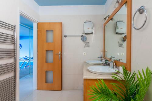 a bathroom with two sinks and a mirror at WhiteBlue Spa Villa, By IdealStay Experience in Heraklio Town