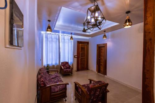 a living room with chairs and a chandelier at Batuta Maldives Fourson in Thulusdhoo