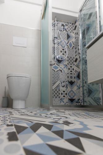 a bathroom with a toilet and a glass shower stall at Nà Nonna Affittacamere in Favignana