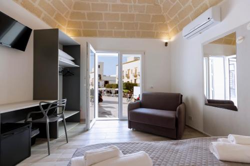 a bedroom with a bed and a chair and a desk at Nà Nonna Affittacamere in Favignana