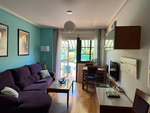 salon z fioletową kanapą i stołem w obiekcie TERRAZA PLAYA BAIONA w mieście Baiona
