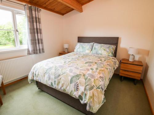 a bedroom with a large bed and a window at The Log Cabin in Tenbury