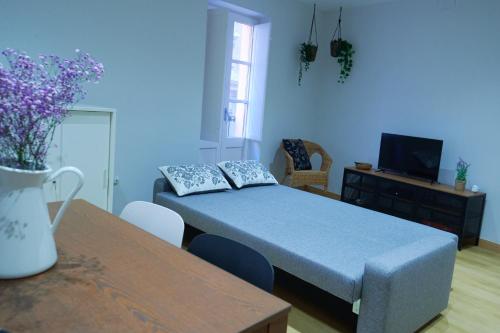ein blaues Zimmer mit einem Bett und einem Tisch in der Unterkunft Pretty town hall apartment in Tarragona