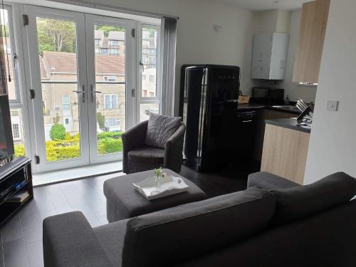 a living room with a couch and chairs and a kitchen at Modern Apartment with Stunning Sea View in Weston-super-Mare