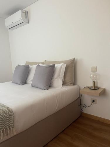 a bed with white sheets and pillows in a room at Casa do Afonso in Brufe