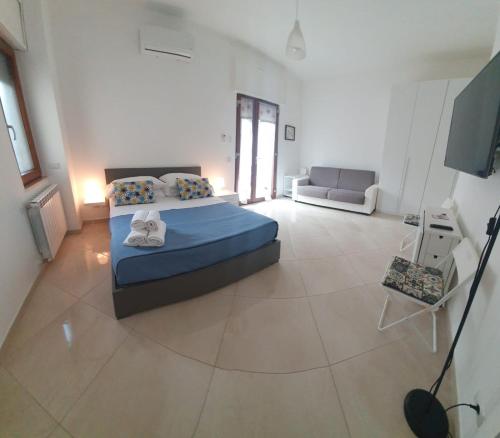 - une chambre avec un lit bleu et un canapé dans l'établissement Corner Terrace Sorrento Coast, à Sant'Agnello