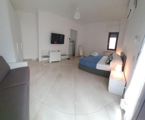- une chambre avec un lit, un canapé et une télévision dans l'établissement Corner Terrace Sorrento Coast, à Sant'Agnello