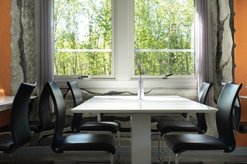 einen weißen Tisch und Stühle vor einem Fenster in der Unterkunft Sandvik Gjestegård in Sandvik