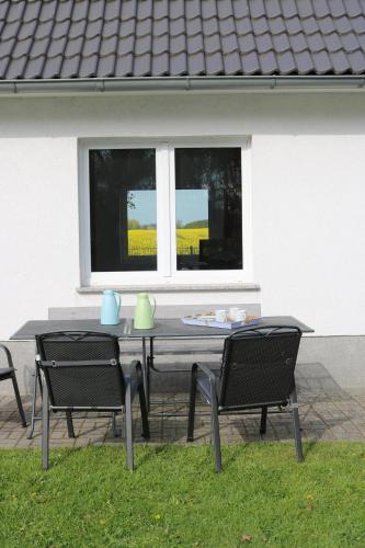 a table and chairs in front of a window at Kleines Haus am Feld in Rehna