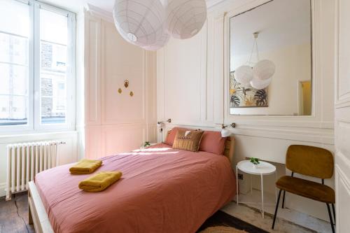 sypialnia z dużym łóżkiem z 2 żółtymi ręcznikami w obiekcie Le Ara Bleu - Bel appartement de caractère w Saint-Malo