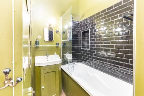 W łazience znajduje się wanna, umywalka i wanna. w obiekcie Le Ara Bleu - Bel appartement de caractère w Saint-Malo