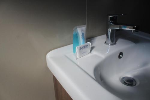 a bathroom sink with a soap holder on it at Bayside Hotel Empangeni in Empangeni