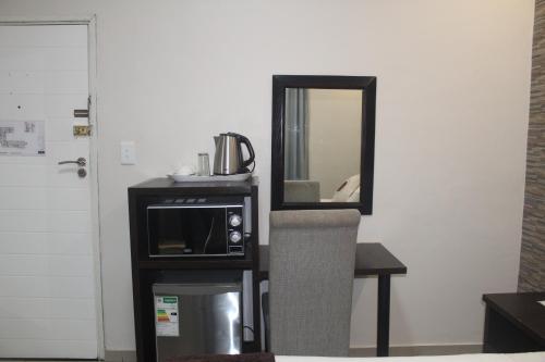 a mirror sitting on a wall next to a microwave at Bayside Lodge Empangeni in Empangeni