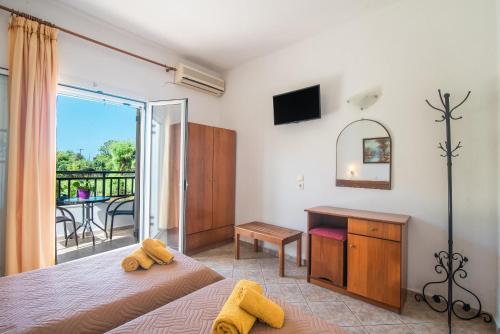 a bedroom with a bed and a desk and a balcony at Aleka Apartment 1 in Agios Georgios