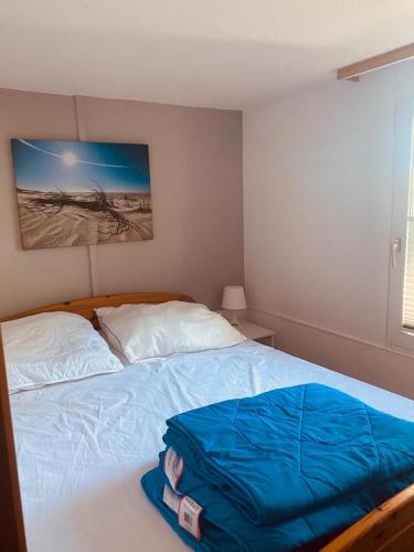 a bedroom with a bed with a blue bag on it at Bungalow "Strandblick" in Göhren