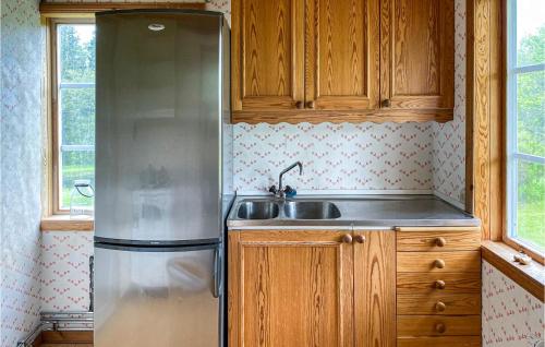 Una cocina con frigorífico de acero inoxidable y fregadero. en Stunning Home In Tranhult With Kitchen, en Tranhult