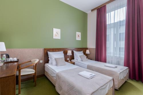 Pokój hotelowy z 2 łóżkami i biurkiem w obiekcie Hotel Yarden by Artery Hotels w Krakowie
