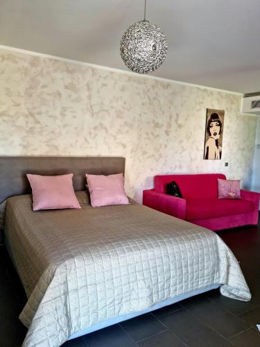 a bedroom with a bed and a pink couch at Maison Marquet in Cap d'Ail