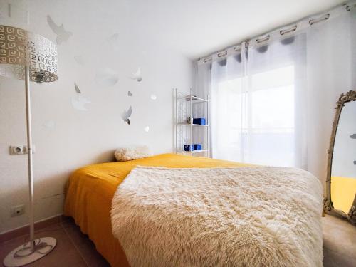 ein Schlafzimmer mit einem Bett und einer Stehlampe in der Unterkunft ESTRELLA honey apartment in Cala de Finestrat