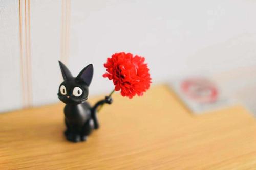 a black bunny holding a red flower on a table at TIME SHARING STAY Ikebukuro in Tokyo