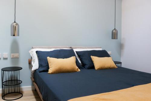 a blue bed with two yellow pillows on it at Casa Chiara in Cefalù