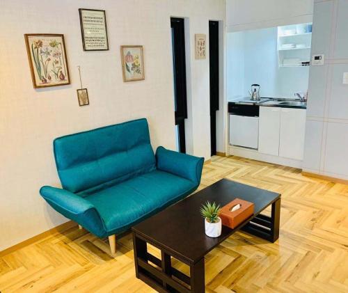 a living room with a blue couch and a table at TIME SHARING STAY Ikebukuro in Tokyo