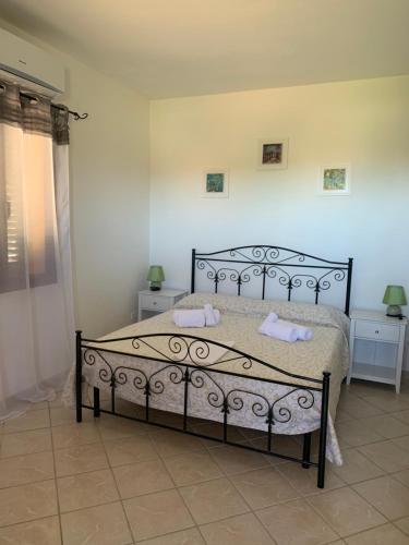una camera da letto con un letto e due asciugamani di B&B La Petra Longa a San Teodoro