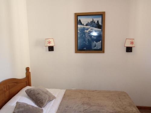 une chambre avec un lit et un tableau au mur dans l'établissement Charmant T2 pour 4 pers avec balcon, piscine, sauna à Val-Cenis - FR-1-508-265, à Lanslebourg-Mont-Cenis