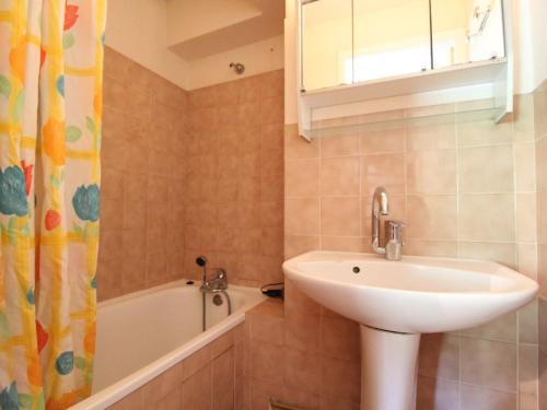 W łazience znajduje się umywalka i wanna. w obiekcie Appartement pour 6 personnes au pied des pistes à Val Cenis Lanslevillard - FR-1-508-264 w mieście Lanslevillard