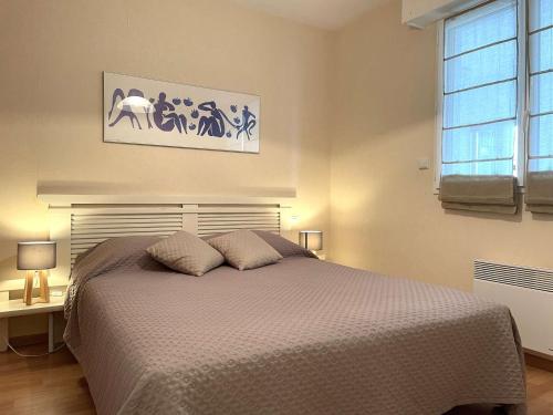 une chambre avec un lit avec deux oreillers dessus dans l'établissement Confortable appartement avec piscine, golf, et parking - FR-1-224-789, à LʼAiguillon-sur-Vie