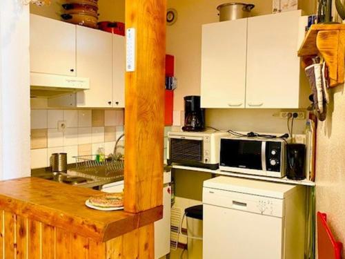 une petite cuisine avec des armoires blanches et un micro-ondes dans l'établissement Bel Appartement 3 Pièces au Pied des Pistes à Villard-de-Lans - Balcon Exposé Sud - FR-1-515-129, à Villard-de-Lans